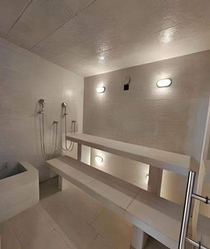 a white bathroom with a bench and a shower at Eira by Colproperty Management in Santa Marta