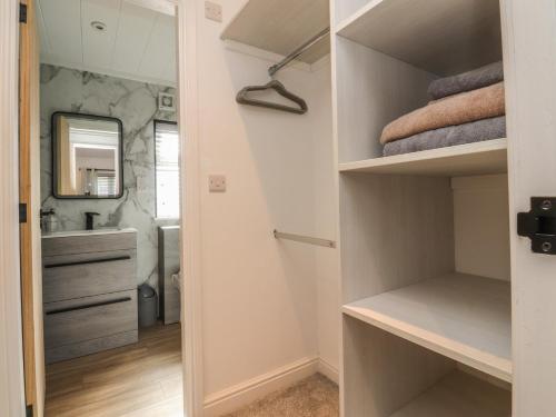a walk in closet with a sink and a mirror at Number 35 in Blackburn