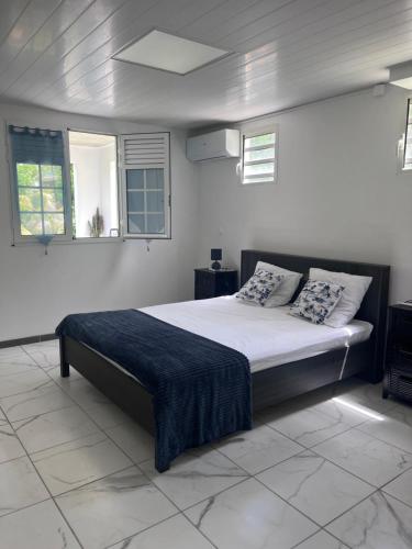 a bedroom with a bed with a blue blanket on it at Résidence Atoumo in Rivière-Pilote