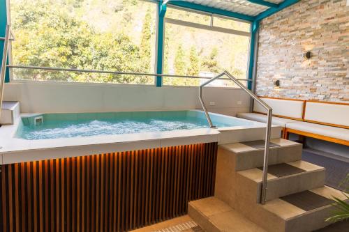 a hot tub in a room with a large window at Xperience Hotel in Baños