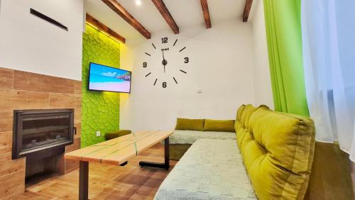 a living room with a couch and a clock on the wall at Urocza Kryjówka ze SPA in Lesko