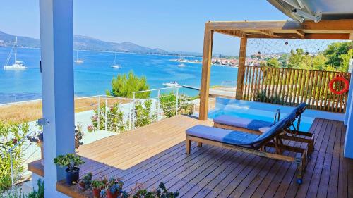 a porch with a bench and a view of the water at Villa Tulivu in Paleros