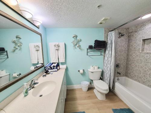 a bathroom with a sink and a toilet and a tub at Sunkissed-Modern Oceanfront Condo Daytona Beach in Daytona Beach