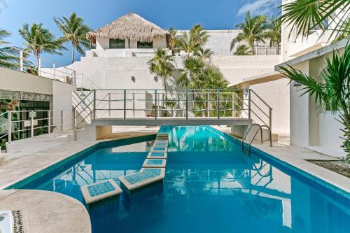 a swimming pool with lounge chairs in front of a building at Luciana Hotel & Beach Club in Playa del Carmen
