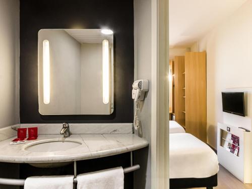 a bathroom with a sink and a mirror at ibis Uberaba in Uberaba