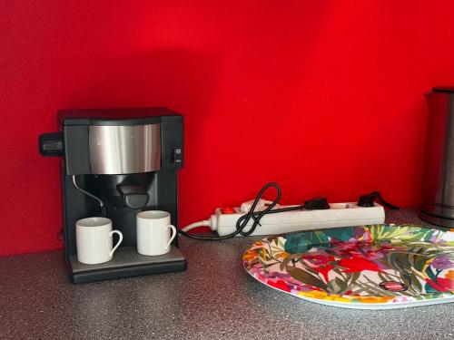 a coffee maker and a plate with coffee cups at Modern Stay Apartments in Kassel
