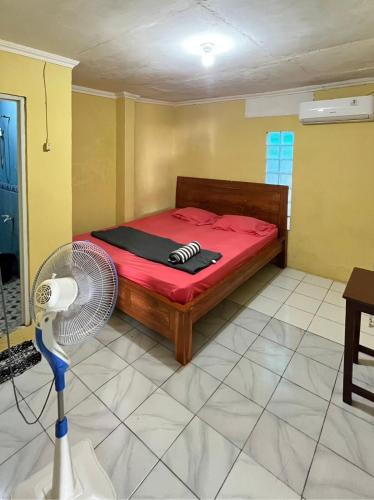 a bedroom with a bed and a fan in a room at Motel Gemilang in Karimunjawa