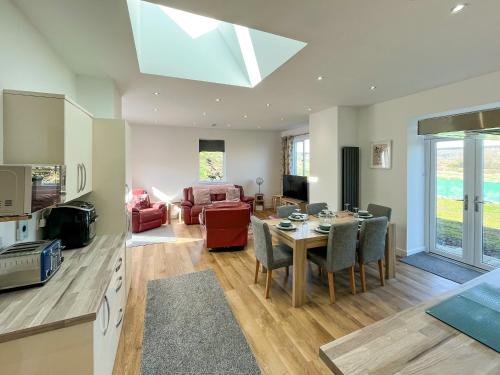a kitchen and living room with a table and chairs at North Lodge in Forgandenny