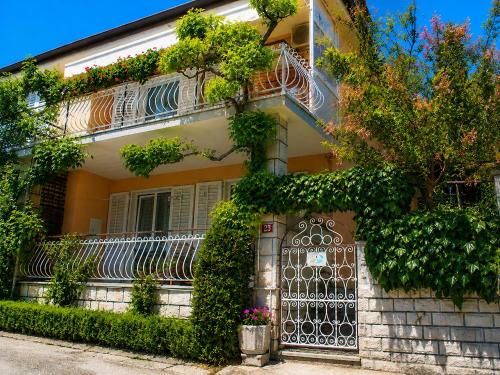 a house with a gate and ivy at Apartments Furlan in Portorož