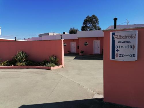 a sign in front of a building with a parking lot at Ribeirotel in Albergaria-a-Velha