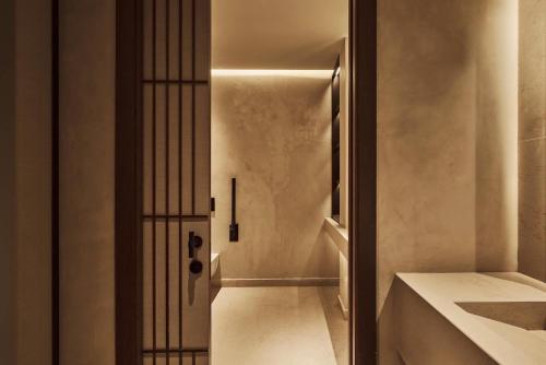 a hallway with a door leading to a bathroom at Nobu Hotel Madrid in Madrid