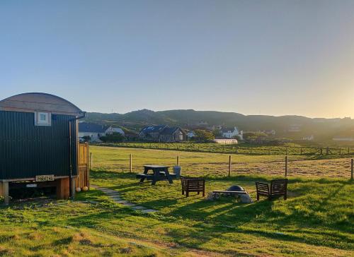 a field with a shed and a picnic table at Bothan na Mara in Valtos