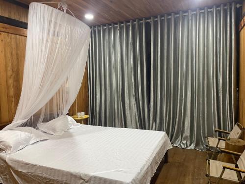 a bedroom with a bed with a mosquito net at Thàng Khám homestay in Lũng Giên