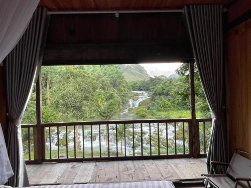 a bedroom with a view of a river from a window at Thàng Khám homestay in Lũng Giên