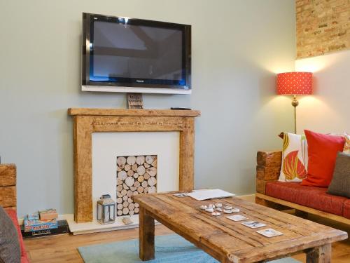 a living room with a fireplace with a tv above it at 'Ow Do - Uk11446 in Skipsea