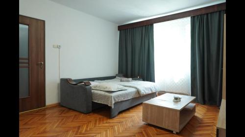 a bedroom with a bed and a coffee table at Apartament Maria in Turda