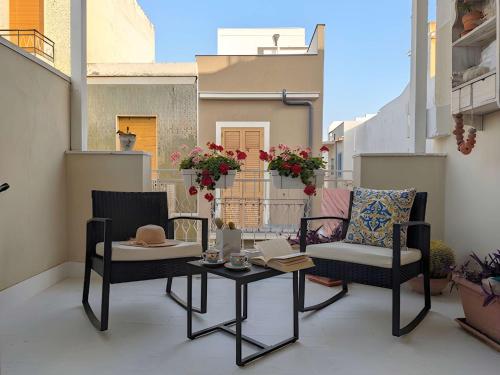 a patio with two chairs and a table on a balcony at Libeccio House in Avola