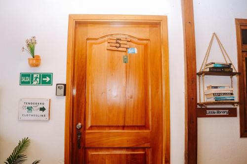 a wooden door in a room next to a wall at #5 Mini Suite, Cerca de Todo, 2-3 people - AC in Puerto Ayora