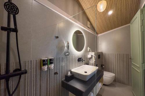 a bathroom with a sink and a toilet and a mirror at Hamta 270 Cliff Resort - 270 Degree Mountain View Suites, Sethan Manali in Manāli