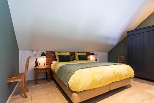 a bedroom with a bed with a yellow bedspread at Thús yn Hantum Vakantiehuisje met hottub in Friesland in Hantum