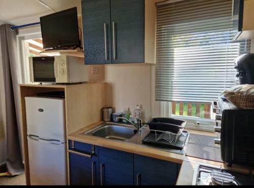 a small kitchen with a sink and a refrigerator at Schatzele in Boofzheim