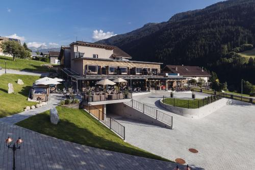 Ein Gebäude mit einem Restaurant vor dem Hintergrund eines Berges in der Unterkunft Genusshotel Vermala Montafon in Sankt Gallenkirch