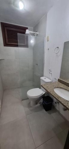 a bathroom with a toilet and a sink and a mirror at Pouso do Kite Pousada Flecheiras in Flecheiras