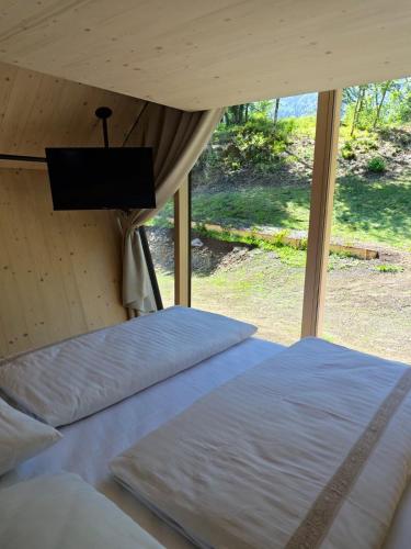 a bedroom with a bed with a view of the grass at Glamp Camp Danica in Bohinj