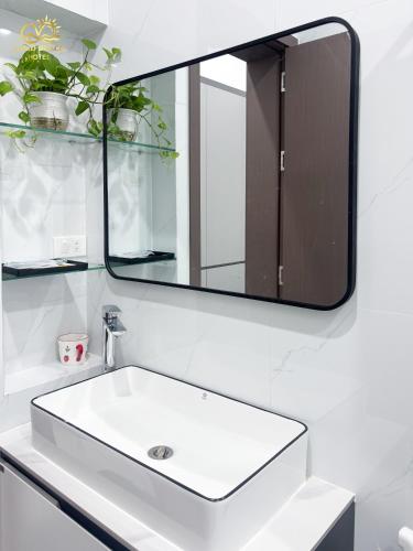 a bathroom sink with a large mirror above it at Hotel Gold Beach in Phương Phi