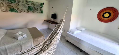 a bedroom with a hammock bed and a tv at Pouso do Kite Pousada Flecheiras in Flecheiras