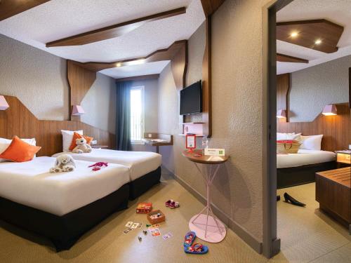a hotel room with two beds and toys on the floor at ibis Styles Gien in Gien