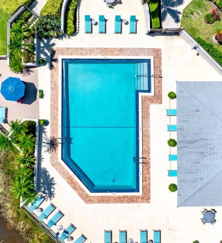 an overhead view of a swimming pool in a resort at Upscale 2BR Townhome Golf, Pools & Lake Views in Palm Beach Gardens
