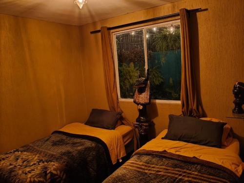 a room with two beds and a window at umbral luxury apartment in Tlajomulco