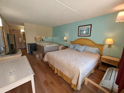 a bedroom with a bed and a bathroom with a tub at Richmond - Quality Quarters Inn in Richmond