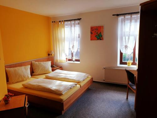 a bedroom with two beds and two windows at Hotel & Restaurant Klosterschänke in Ruhla