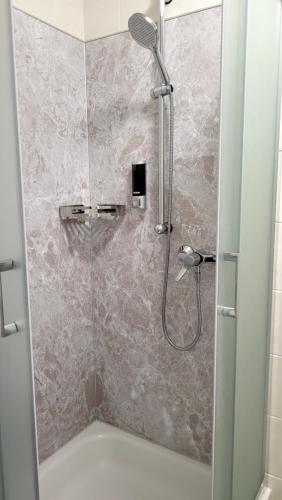 a shower with a glass door in a bathroom at Hotel & Restaurant Klosterschänke in Ruhla