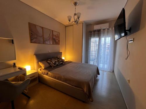 a bedroom with a bed with a television and a window at Sea and Cinema,two bedrooms apartment in Loutraki