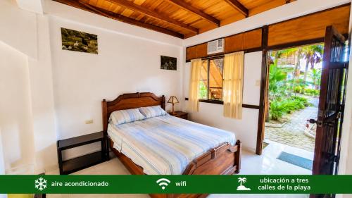 a bedroom with a bed and a large window at Suites Villa Colombia in Puerto López