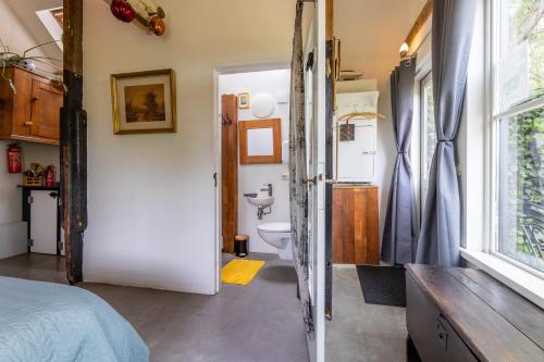 a bathroom with a bed and a toilet in a room at The Stables in Kampen