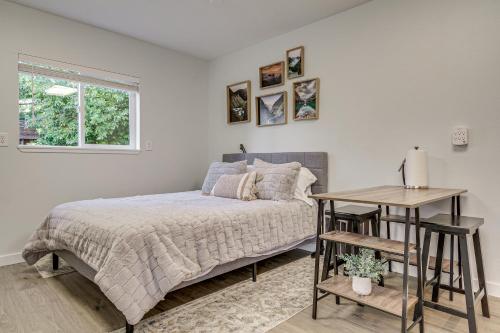 a bedroom with a bed and a table and a window at Pet-Friendly Quaint Cottage: Park-Like Setting in Monroe