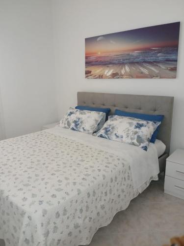 a bedroom with a white bed with blue pillows at La Casa Bianca in Camerano
