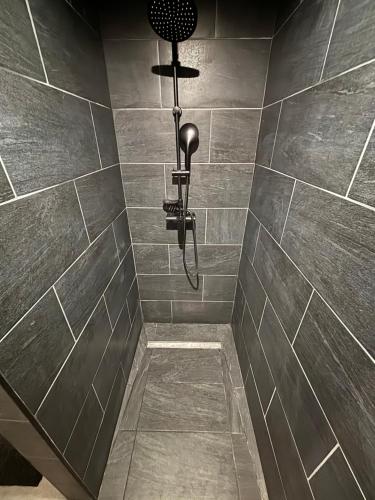 a bathroom with a shower with a light on the wall at Maison convivial in Vireux-Wallerand