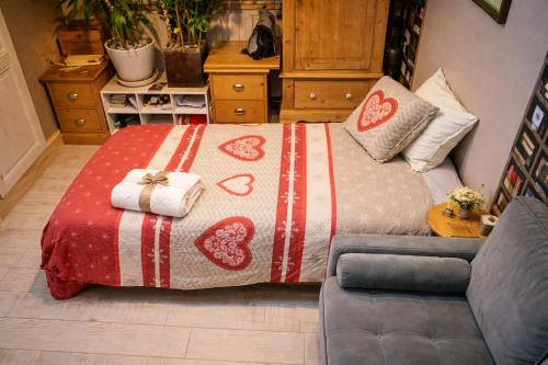 a bedroom with a bed with a blanket and a couch at Un coin de paradis in Oullins