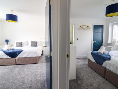 a bedroom with two beds and a mirror at Kingfisher in Talybont