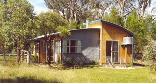 a small house in the middle of a field at Whiskey Gully Cottages in Stanthorpe
