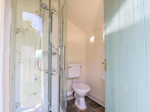 a bathroom with a toilet and a glass shower at The Bowtop Gypsy Caravan in Eye