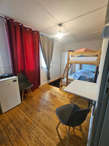 a room with two bunk beds and a desk and chairs at Domek Wakacyjny Patrycja 47 in Głębokie