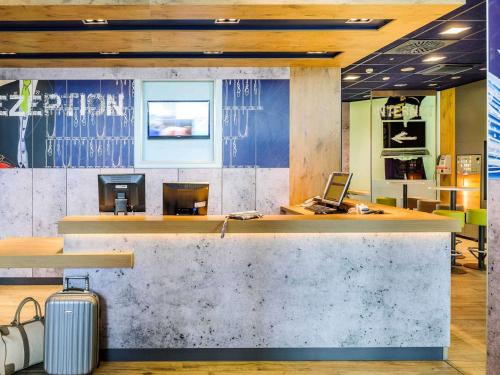 a lobby with a bar with a suitcase in front of it at Hotel Ibis Budget Deauville in Deauville