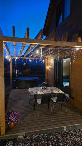 a table and chairs on a deck at night at Lipowe Love in Lipowa