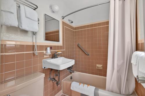 a bathroom with a sink and a bath tub at Starfire Motel in Wildwood